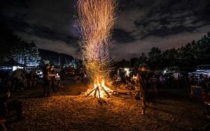 people standing next to bonfire